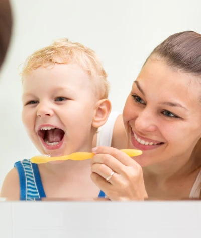 Woman brushing childs teeth
