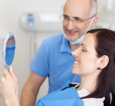 Woman smiling at mirror with man behind her looking at the mirror